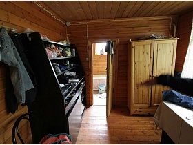 деревянный шкаф для одежды у двери,черный открытый шкаф в прихожей деревянной дачи музыканта
