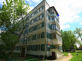 жилая пятиэтажка с застекленными балконами на торце здания в областном квартале