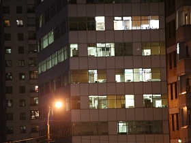 торец многоэтажного здания с большими окнами в жилом городском квартале по улице Крылатские холмы в ночное время