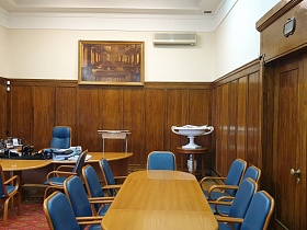 деревянные кресла с подлокотниками и синей кожаной обивкой вокруг полированных столов без углов в светлом кабинете Министра СССР с высокими панелями из натурального дерева в аренду для съемок кино