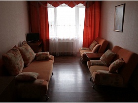 мягкий персиковый диван и кресла с подушками в красной комнате на базе отдыха Юг