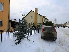 ровные ряды небольших домов на широкой улице поселка в зимнее время