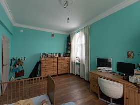 общий вид просторной спальной комнаты с коричневой мебелью у бирюзовых стен современной квартиры в сталинском доме