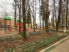 яркая детская игровая площадка в провинциальном дворике немецких трехэтажек