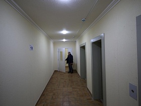 два лифта выходят на площадку с белыми стенами и потолком