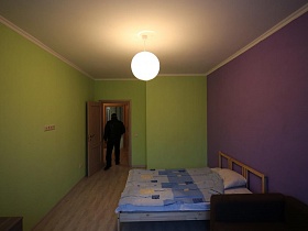 интересное сочетание стен салатового и сиреневого цвета с кремовым потолком в спальне квартиры с евро ремонтом