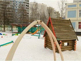 сказочный деревянный домик,горка, песочница, качели на зимнем участке детского сада