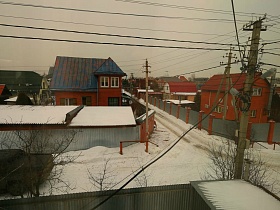 вид из окна на соседние дачи и проезжую дорогу в зимнее время