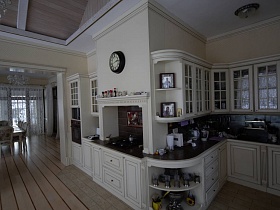 белая красивая кухня со множеством шкафчиков и темной рабочей поверхностью