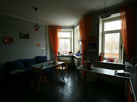 общий вид уютной светлой кухни с ораньжевыми гардинами на эркерных окнах современной трехкомнатной квартиры ИКЕА стиль