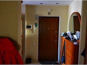 подкова над входной дверью с глазком и домофон с видеокамерой в прихожей трехкомнатной квартиры панельного дома