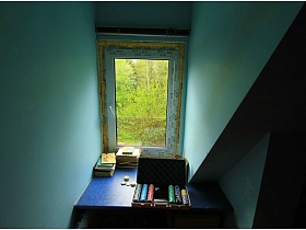 встроенный письменный стол у нового пластикового окна небольшой комнаты в мансарде двухэтажной дачи