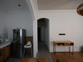 стена из гипсокартона, разделяющая кухню и гостинную с арочным перекрытием в скандинавской квартире