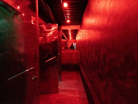 длинный узкий коридор к общественным местам молодежного ночного клуба в красном свете