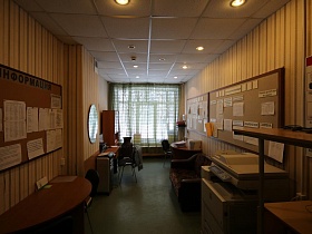 информационные стенды со столиком и диваном у стены школы