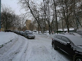 расчищенная дорога от снега вдоль жилой панельной пятиэтажки
