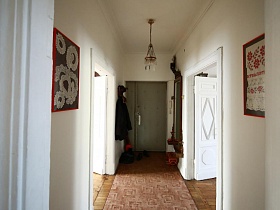 у входной двери вешалка для одежды и длинное зеркало в деревянной рамке времен эпохи СССР