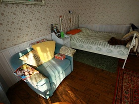 кресло-кровать с подушками у стены в спальне на первом этаже особняка