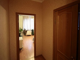 коричневые двери в бежевом коридоре современной квартиры молодоженов на втором этаже многоэтажного дома