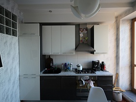 белые дверцы пинала и навесных шкафов серой мебельной стенки на кухне трехкомнатной квартиры двух эпох в жилом доме