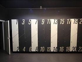 чередование черных и белых шкафчиков с нечетными номерами сверху и четными снизу в современной просторной спортивной раздевалке