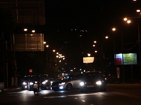 огромные рекламные банеры вдоль проезжей достаточно освещенной дороги по улице Крылатские Холмы