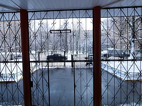 металический забор и ворота отделяют школу от дороги