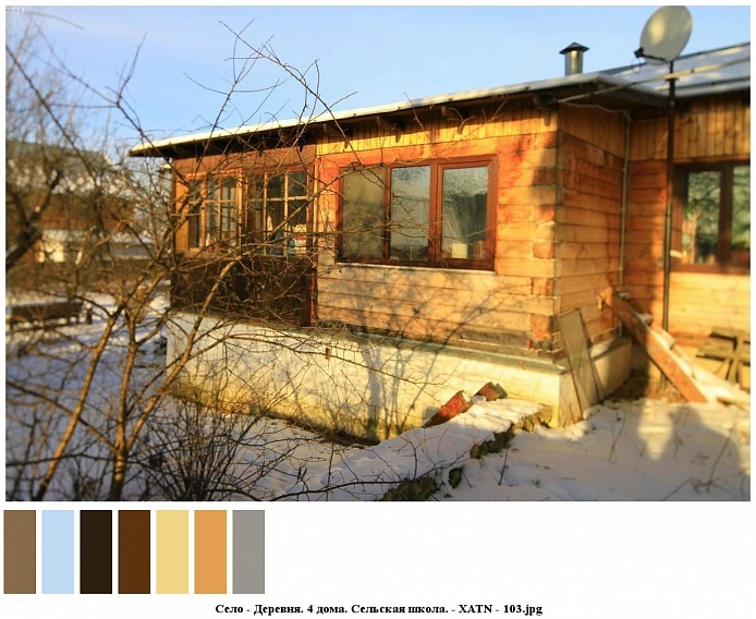 один из сельских жилых деревянных домов на высоком цоколе, большими окнами и верандой на участке, припорошенным снегом