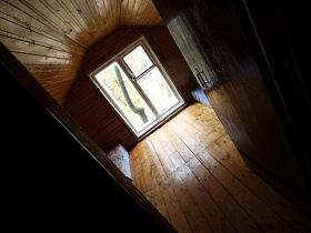 деревянные стены, пол и потолок в спальной комнате на мансарде небольшого жилого домика у пруда