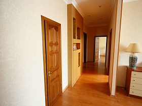  светлые стены и новый коричневый линолеум на полу гостиной,коридора и прихожей в трехкомнатной современной квартире в жилом доме