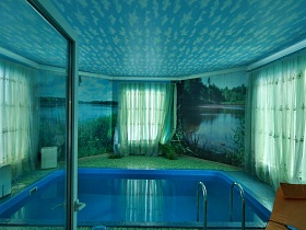 водные картины на стенах между большими окнами с голубой гардиной в голубой комнате с бассейном через открытые двери спортивной комнаты художественной дачи в сосновом лесу