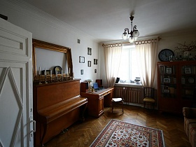 пестрый цветной ковер посередине гостиной квартиры в сталинке