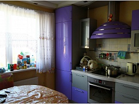 яркая сиреневая кухня в приличной трехкомнатной квартире панельного дома