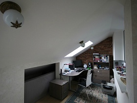 небольшая светлая рабочая комната в мансарде дома с яркой кухней и частичным недостроем