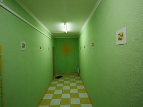 бело желтая квадратная шахматная плитка на полу длинного коридора с салатовыми стенами и светильником на салатовом потолке подъезда жилого дома