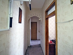 тренажер на стене со светлыми обоями длинного коридора просторной семейной классической квартиры в сталинском доме