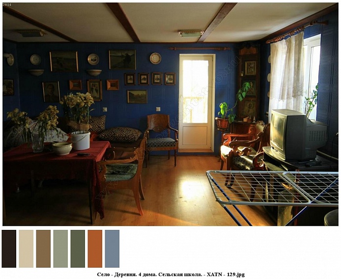 стол, диван, тумба с телевизором, кресла, сушилка для посуды на полу с коричневым линолеумом в голубой комнате сельского дома