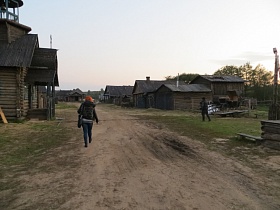 широкая накатанная проселочная дорога между деревянными домами большой деревни начала 20-го века