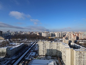 разноплановые высотные жилые дома с двухполосной городской автомобильной дорогой микрорайона города в зимнее время