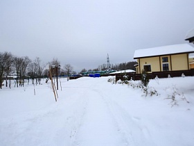  участок дороги  под снегом к современным дачным коттеджам