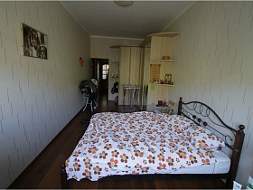 картина на светлых обоях стены напротив большой коричневой кровати с витой спинкой в спальне квартиры педагога