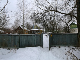 открытые ворота деревянного забора соседнего дачного участка