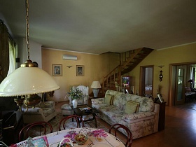 общий вид уютной гостиной с белым потолком и желтыми стенами на лесной даче в соснах