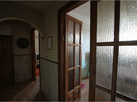 межкомнатные коричневые деревянные двустворчатые двери со стеклянными вставками спальной комнаты простой сталинской квартиры 90-ых годов