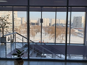 стеклянные стены вдоль всей высоты лестницы современного подъезда в административном здании