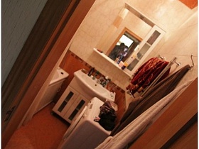зеркало над раковиной со шкафчиком и стиральная машина у стены ванной комнаты в типичной двухкомнатной квартире жилого дома