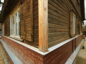 деревянная балка на углу старорусской  избы в деревне