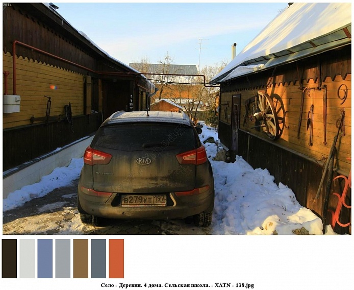 машина на заснеженном дворе деревянного коричневого с желтым дома с хозяйственными постройками