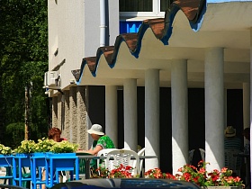 многочисленные вазоны с белыми и красными живыми цветами на террасе гостиницы "Дубна" советского времени в летнее время