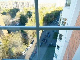 вид из окна трехкомнатной квартиры на проезжую дорогу с машинами в жилом квартале